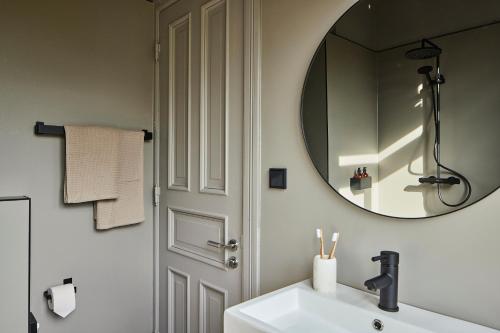 een badkamer met een wastafel en een spiegel bij stilwerk Strandhotel Blankenese in Hamburg