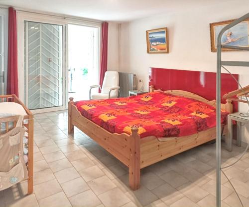 MeynesにあるVilla de 6 chambres avec piscine privee sauna et jardin clos a Meynesのベッドルーム1室(赤い掛け布団付きのベッド1台付)