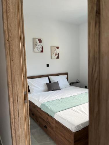 a bed with a wooden frame in a bedroom at faskomilo house 2 in Faskomiliá