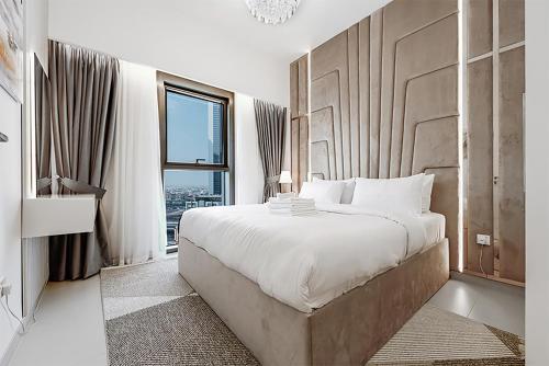 um quarto com uma cama grande e uma janela em Stayis -Spacious & Luxury 1 Bedroom room Apartment em Dubai