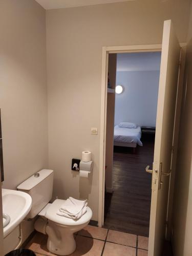 La salle de bains est pourvue de toilettes, d'un lavabo et d'un lit. dans l'établissement Hotel Eisenhower (ex King Hôtel), à Port-en-Bessin-Huppain