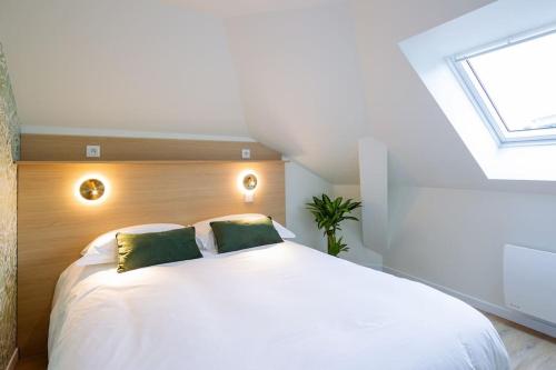 une chambre avec un grand lit blanc avec deux oreillers verts dans l'établissement Appartement 6 proche de la gare et du centre ville, à Amiens