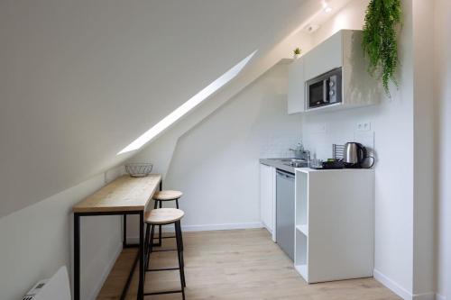 une cuisine avec un comptoir et une table dans un grenier dans l'établissement Appartement 6 proche de la gare et du centre ville, à Amiens