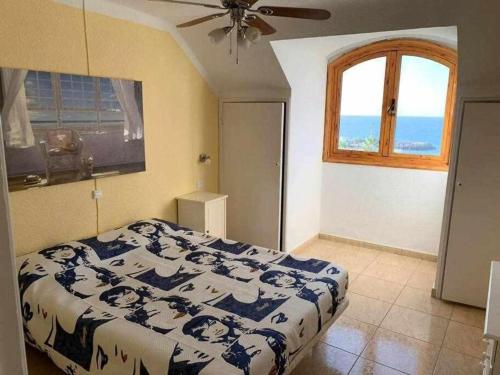 een slaapkamer met een bed en een raam bij Ático con impresionantes vistas al mar in Adeje