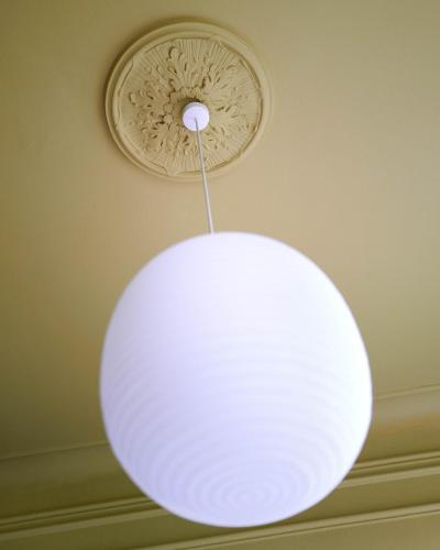 a white orb light hanging from a ceiling at stilwerk Strandhotel Blankenese in Hamburg