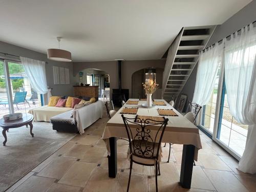 a living room with a table and a couch at Maison de vacances avec piscine in Chancelade