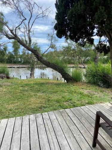 a bench sitting on a wooden deck near a body of water at Les Bains Gardians in Saintes-Maries-de-la-Mer