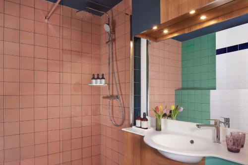 W łazience znajduje się umywalka i prysznic. w obiekcie Avani Museum Quarter Amsterdam Hotel - previously NH Amsterdam Museum Quarter w Amsterdamie