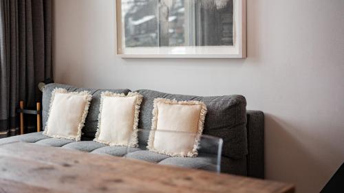 a gray couch with pillows in a living room at Casa delle Stelle by Zermatt Premium Apartments in Zermatt