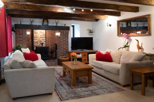 a living room with two couches and a fireplace at Charming Guest House in Cornish Countryside in Bodmin