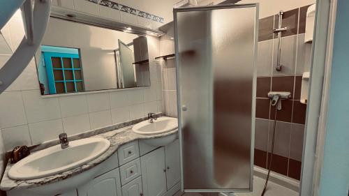 une salle de bain avec deux lavabos et un miroir dans l'établissement Appart du parc, emplacement rêvé, à Saint-Jean-de-Monts