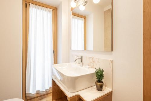 W łazience znajduje się umywalka i lustro. w obiekcie Chalet Falorie w mieście Cortina dʼAmpezzo