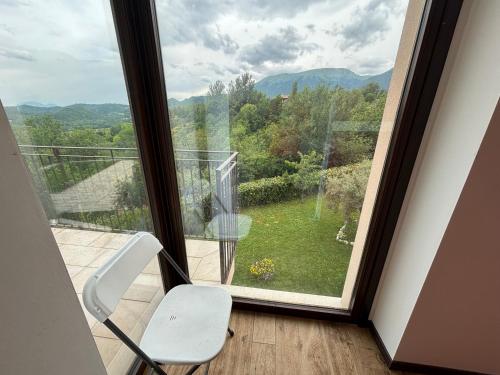 a white chair sitting in front of a window at Casa vacanze Al Cielo in Sarnano