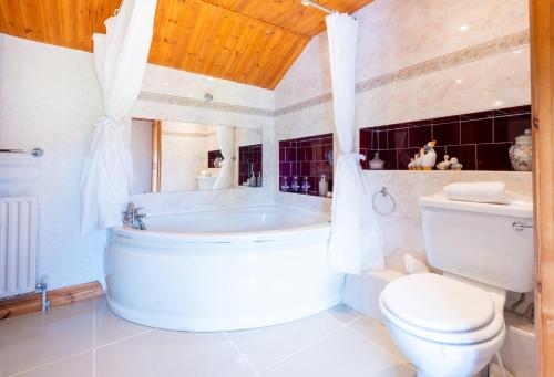 een badkamer met een bad, een toilet en een wastafel bij Charming Guest House in Cornish Countryside in Bodmin