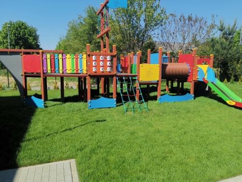 a playground with a colorful play set on the grass at Sześciu Korsarzy in Dębina