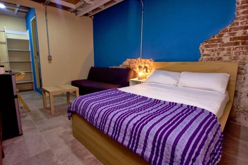 a bedroom with a bed and a chair in a room at Kali Oaxaca Hostel in Oaxaca City