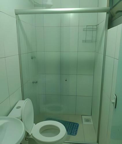 a white bathroom with a toilet and a shower at Apto n.08 baixo custo beneficio in Águas Claras