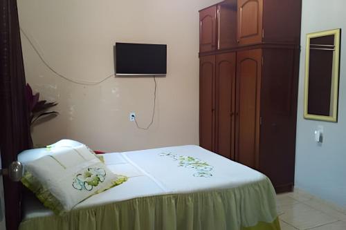 a bedroom with a bed and a tv on the wall at Apto n.08 baixo custo beneficio in Águas Claras