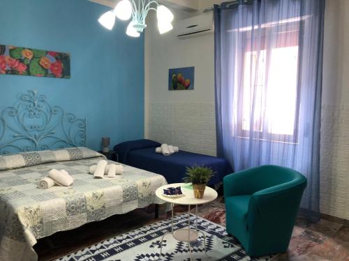 een blauwe kamer met 2 bedden en een stoel bij Scilla A Vinedda in Scilla