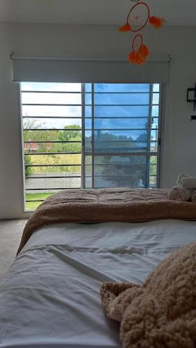 a bedroom with a bed and a large window at Casa Quinta La Bachi in Arturo SeguÃ­