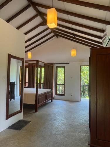 a large room with a bed and a mirror at Bali Villa Mirissa in Mirissa