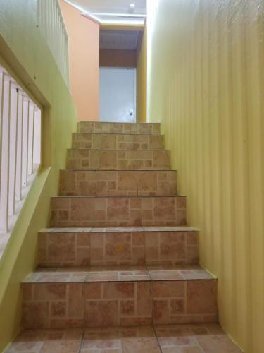 a set of stairs in a hallway with yellow walls at Queste Ochi Town House in Ocho Rios