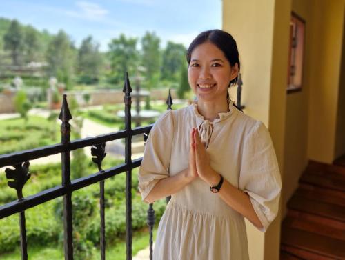 a woman standing with her hands in front of a balcony at Biciclette hotel khaoyai in Ban Bung Toei
