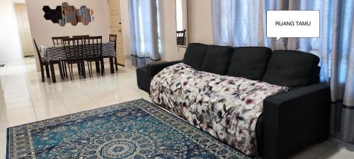 Farwis Homestay في Mukah: غرفة معيشة مع أريكة وطاولة