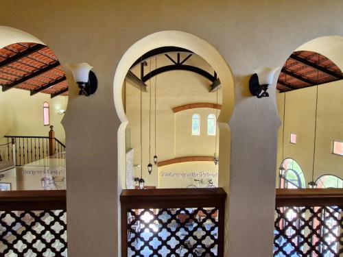 a room with three arched windows and a door at Biciclette hotel khaoyai in Ban Bung Toei