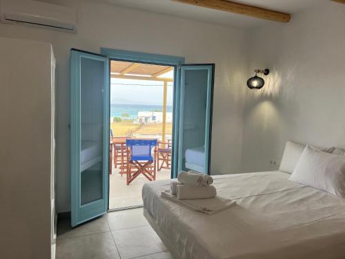 a bedroom with a bed and a view of the ocean at Studios Venetsanos in Koufonisia
