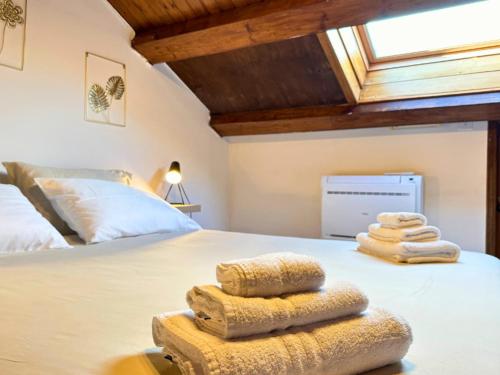 una camera da letto con un letto e asciugamani di Oasi sul Mare - A soli 1 Minuto a Piedi dalla Spiaggia a Senigallia