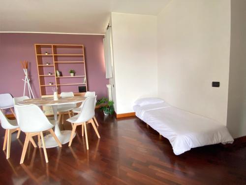 a room with a bed and a table and chairs at Sunset Escape Apartment - panoramic terrace in Fiumicino