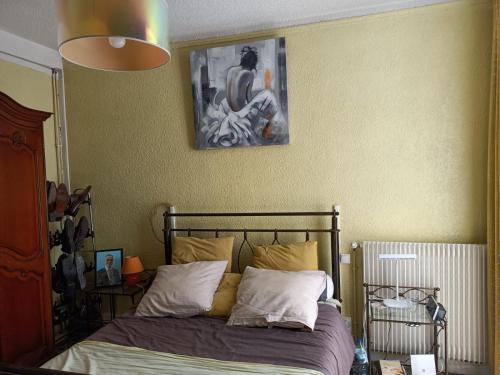 - une chambre avec un lit et une photo sur le mur dans l'établissement Élisée-Perpignan, à Perpignan