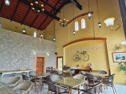 a restaurant with tables and chairs and a bike on the wall at Biciclette hotel khaoyai in Ban Bung Toei