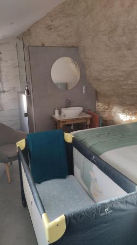 a bedroom with a bed and a bathroom with a sink at Casa Cueva Las Chicas del Puente in Setenil