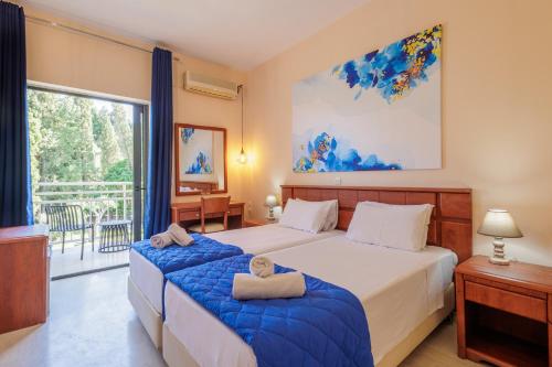 a bedroom with two beds and a large window at Primavera Hotel in Dassia