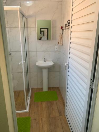 uma casa de banho com um lavatório e um chuveiro em Pousada Quinzitão - O seu local de descanso! em Extrema