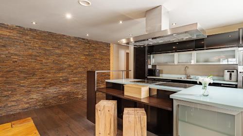 a kitchen with a brick wall at Casa Della Luce Apartments by Zermatt Premium Apartments in Zermatt