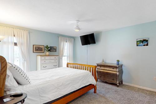 a bedroom with a bed and a dresser and a television at Desert Sun Retreat in Sun City
