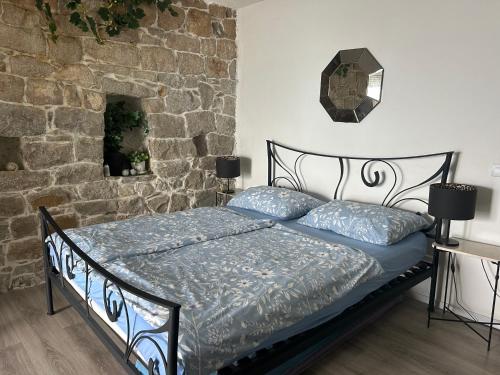 a bed in a room with a stone wall at Apartment Kuk in Split