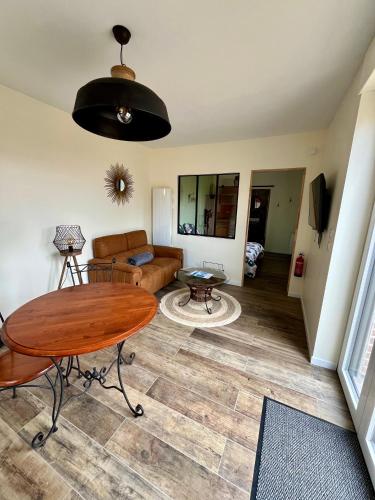 un salon avec une table et un canapé dans l'établissement La Laiterie, gîte au Domaine d'Antan, à Ennevelin