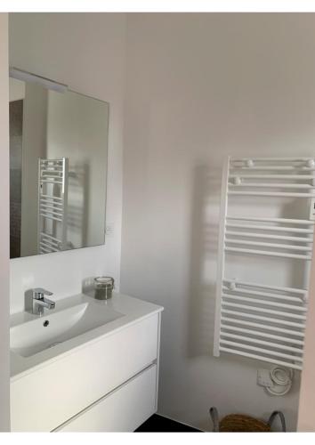une salle de bain blanche avec un lavabo et un miroir dans l'établissement Maison Neuve 3 Chambres avec jardin à 200m du port de la Teste, à La Teste-de-Buch