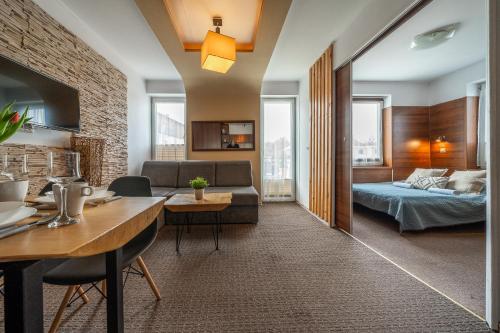 a living room with a bed and a dining room at MAX Apartamenty - Pokoje - Domki - Restauracja - Basen in Mielno