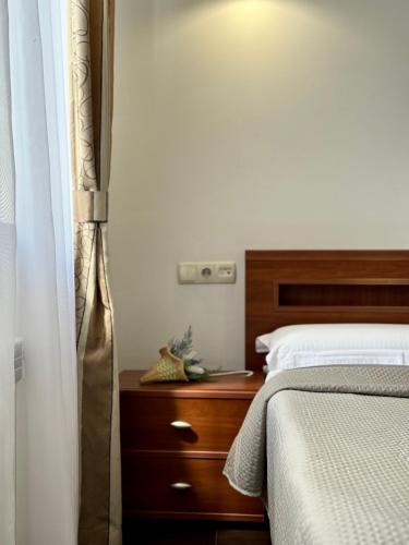 a bedroom with a bed with a wooden headboard and a dresser at Villa Alessia in Skhidnitsa