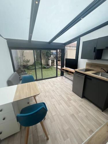 - une cuisine avec deux chaises bleues et une table dans l'établissement Le Lafayette n2 Appart Arles, à Arles