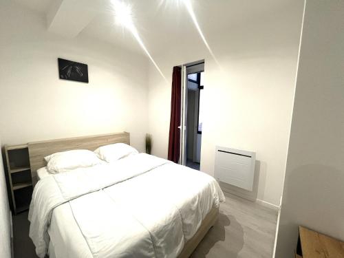 - une chambre avec un lit blanc et une horloge murale dans l'établissement Republique centre 21, à Nice