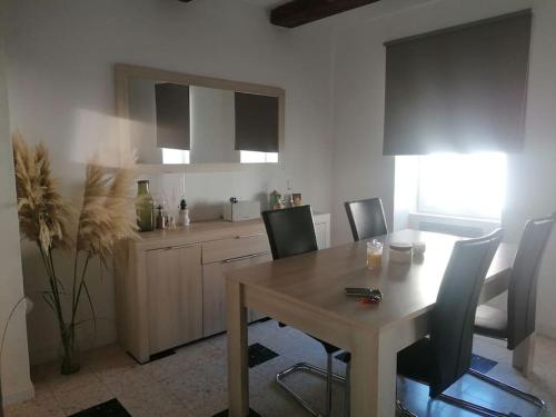 - une cuisine avec une table et des chaises en bois ainsi qu'un comptoir dans l'établissement Maison de village au cœur des causses des Cévennes, à La Vacquerie-et-Saint-Martin-de-Castries