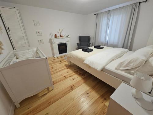 a white bedroom with a bed and a chair at Villa Lindenberg Slovakia in Krupina