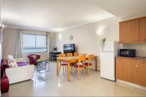 een keuken en een woonkamer met een tafel, een keuken en een eetkamer bij Almog Tower in Haifa