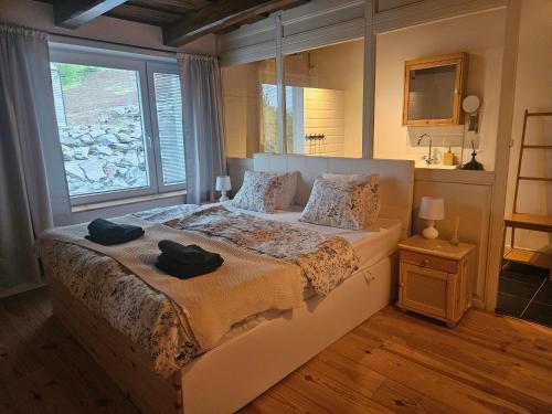 a bedroom with a bed with two black towels on it at Villa Lindenberg Slovakia in Krupina